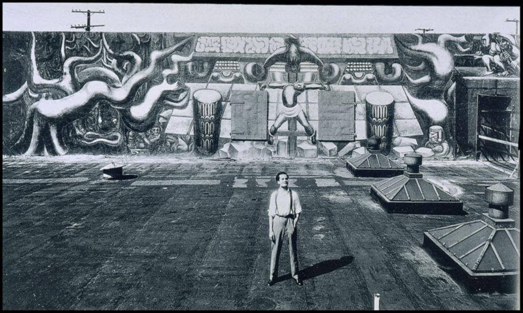 David Siqueiros in front of his mural America Tropical on Olvera Street, 1932 (Artstor)
