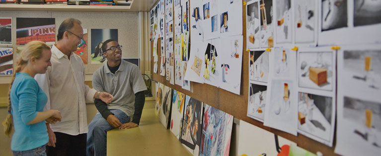 Students and faculty look at work during a digital media class.