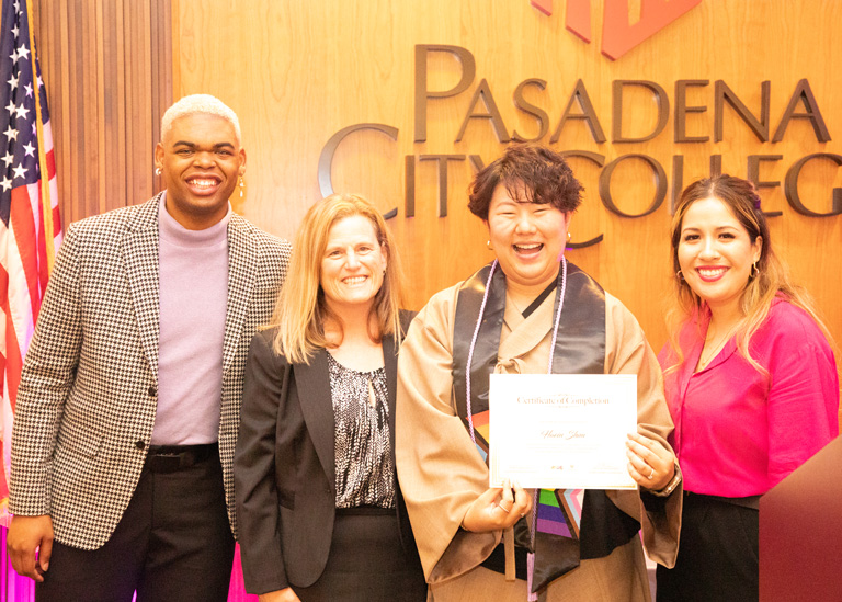 Student accepting scholarship from president and program directors